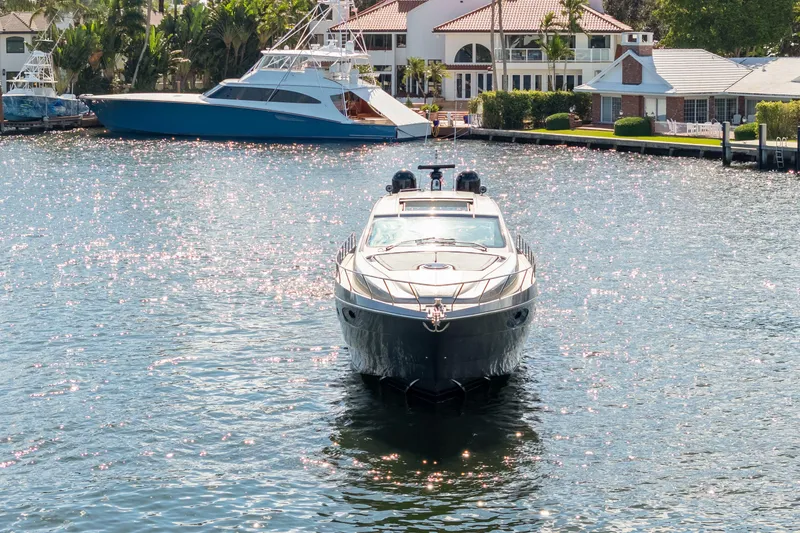 Slide: The Image of 2016 Pershing 62' yacht on sparkling water near luxury waterfront homes. - 2