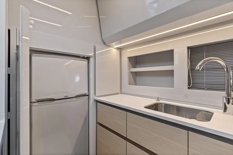 Slide: The Image of Modern kitchen interior of 2016 Pershing 62' yacht with sleek cabinetry and stainless steel sink. - 25