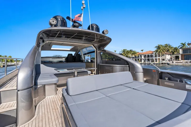 Slide: The Image of 2016 Pershing 62' yacht with spacious deck, luxurious seating, and waterfront view. - 8