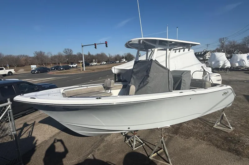 Slide: The Image of 2026 Sea Hunt Ultra 229 boat on display, elevated on stands, in a parking lot. - 11