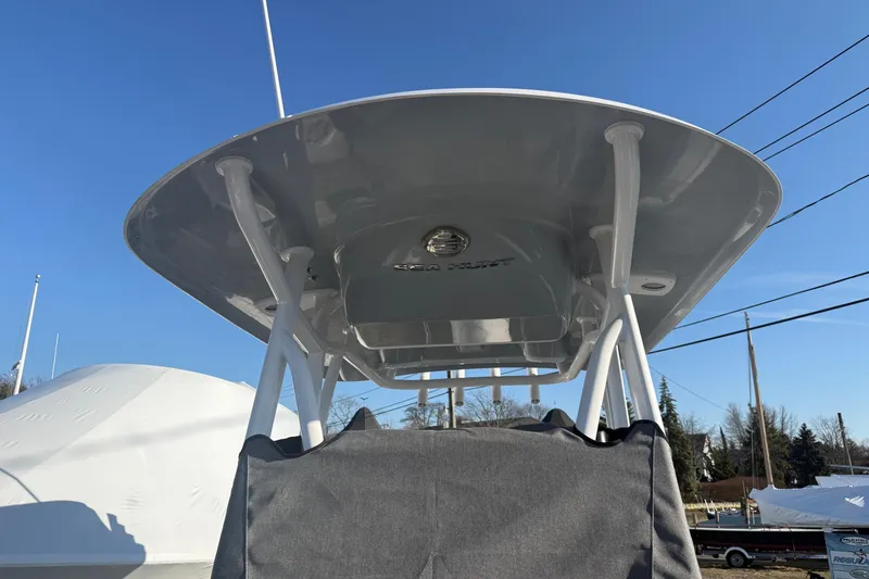 Slide: The Image of 2026 Sea Hunt Ultra 229 boat with T-top against clear blue sky. - 13