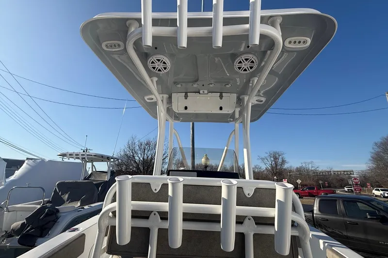 Slide: The Image of 2026 Sea Hunt Ultra 229 boat with T-top and rod holders under clear blue sky. - 16