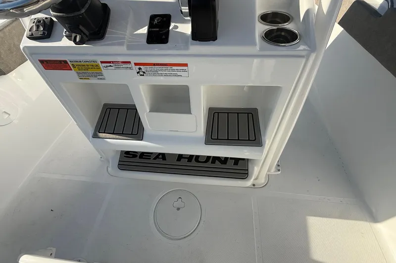 Slide: The Image of 2026 Sea Hunt Ultra 229 boat console with cup holders and storage compartments. - 17