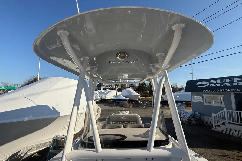 Slide: The Image of 2026 Sea Hunt Ultra 229 boat with T-top at a marina. - 22