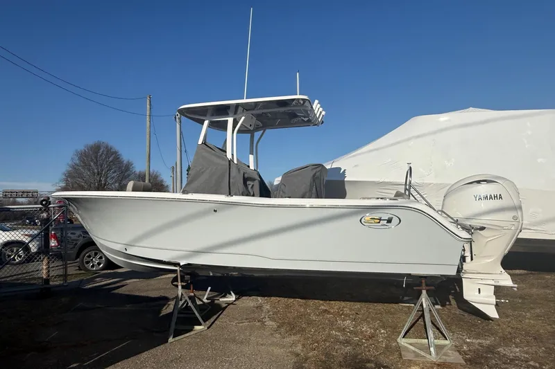 Slide: The Image of 2026 Sea Hunt Ultra 229 boat on stands, featuring Yamaha engine, under clear blue sky. - 5