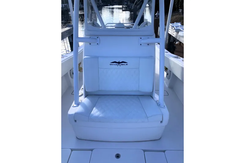 Slide: The Image of 2020 Invincible 33 Open Fisherman boat seat with logo, docked by water. - 35