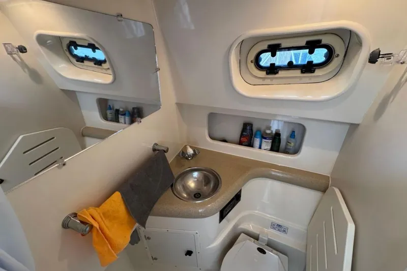 Slide: The Image of 2002 Pursuit 3000 Express boat docked in a marina, surrounded by palm trees. - 10