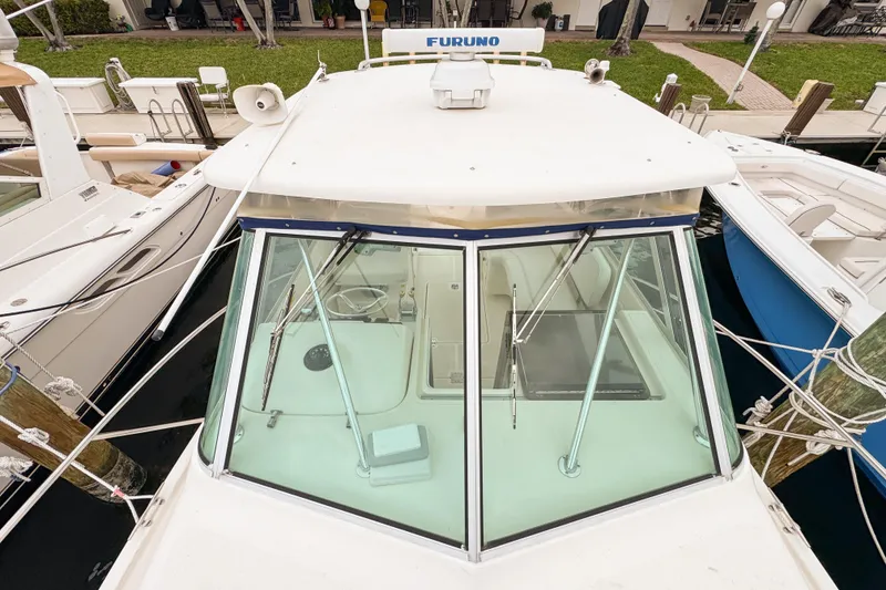 Slide: The Image of 2002 Pursuit 3000 Express boat docked, featuring a Furuno radar system. - 100