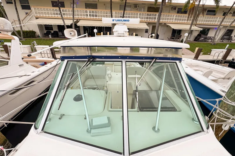 Slide: The Image of 2002 Pursuit 3000 Express boat docked, featuring a clear windshield and Furuno radar. - 101