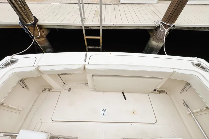 Slide: The Image of 2002 Pursuit 3000 Express boat interior with white seating and dock view. - 107
