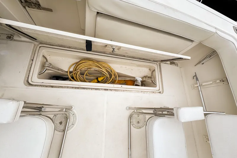 Slide: The Image of Storage compartment on a 2002 Pursuit 3000 Express boat with coiled rope and equipment. - 108
