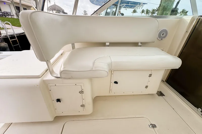 Slide: The Image of 2002 Pursuit 3000 Express boat interior with white seating and storage compartments. - 111