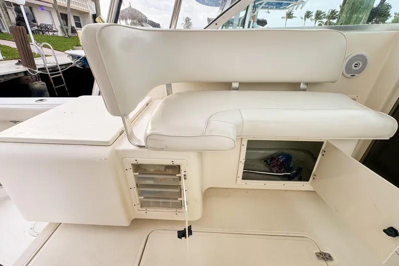 Slide: The Image of 2002 Pursuit 3000 Express boat interior with white seating and storage compartments. - 112