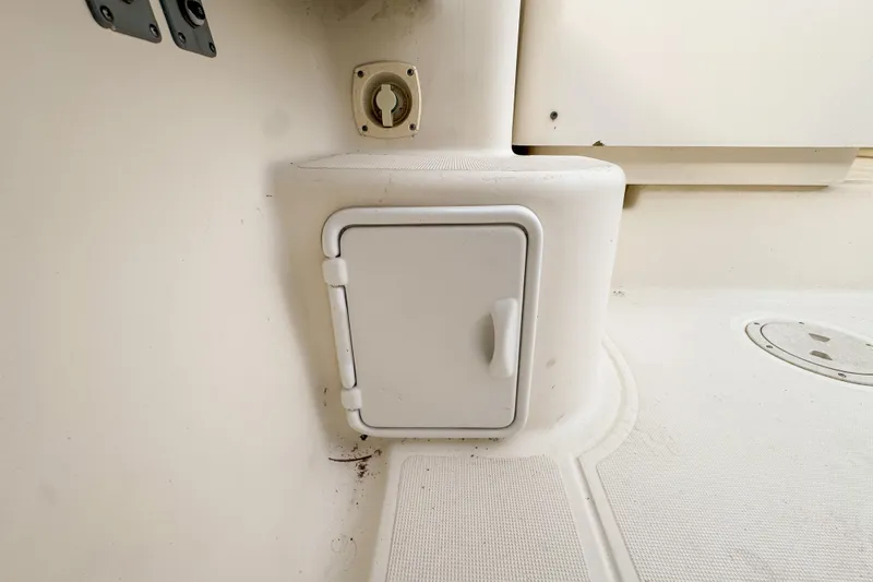 Slide: The Image of 2002 Pursuit 3000 Express boat interior storage compartment with white hatch door. - 114
