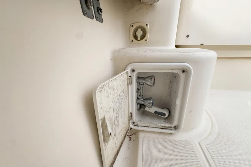 Slide: The Image of 2002 Pursuit 3000 Express boat shower compartment with faucet and hose. - 115