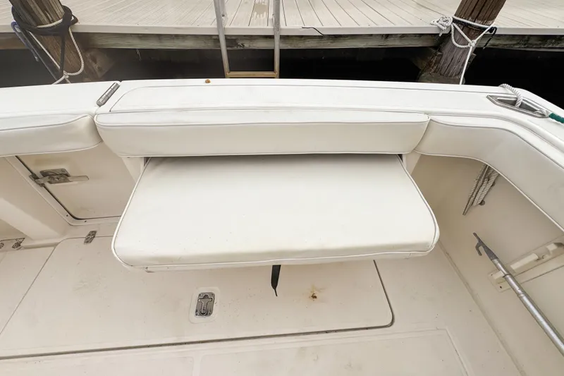 Slide: The Image of 2002 Pursuit 3000 Express boat with white cushioned seating and storage compartments. - 117