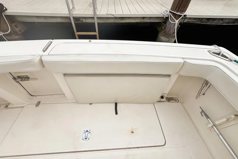 Slide: The Image of 2002 Pursuit 3000 Express boat interior with white cushioned seating and deck. - 118