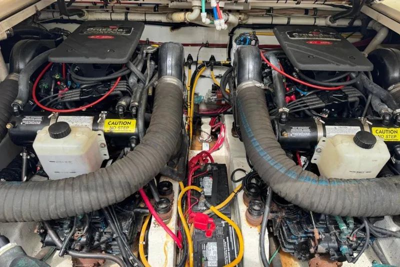 Slide: The Image of Engine compartment of a 2002 Pursuit 3000 Express boat, featuring dual engines and wiring. - 119