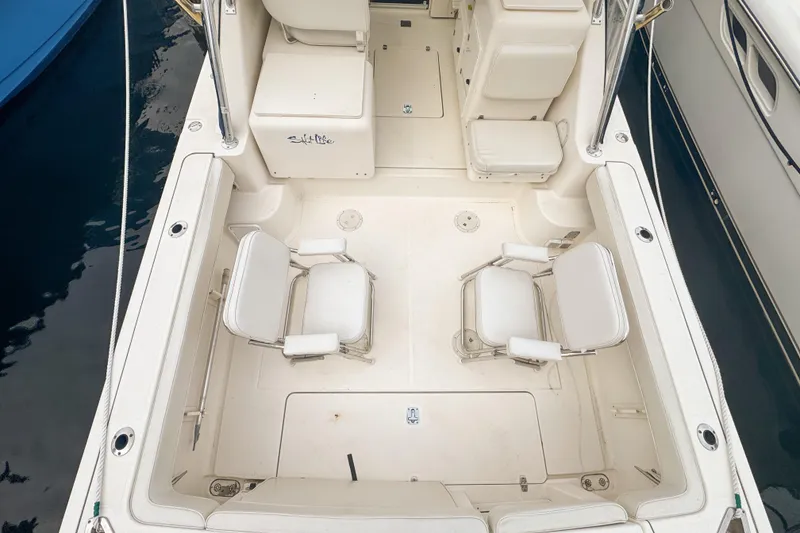 Slide: The Image of 2002 Pursuit 3000 Express boat interior with two white seats and storage compartments. - 15