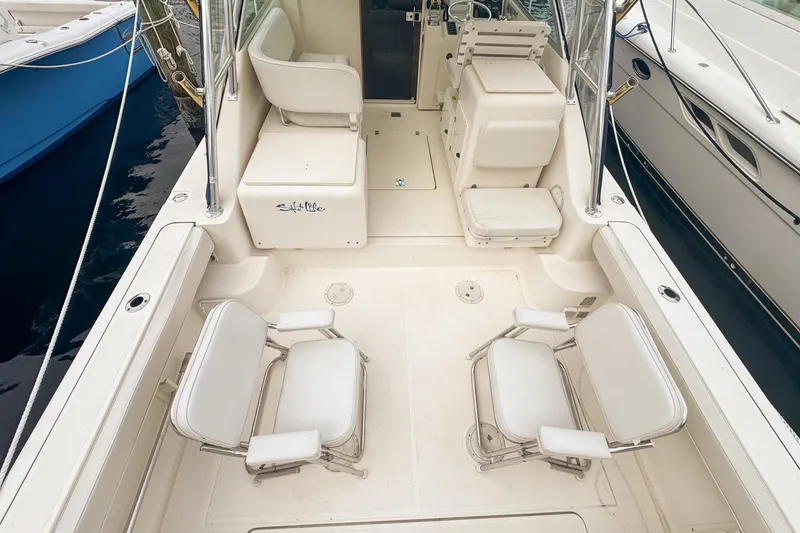 Slide: The Image of 2002 Pursuit 3000 Express boat interior with white seating and fishing rod holders. - 16