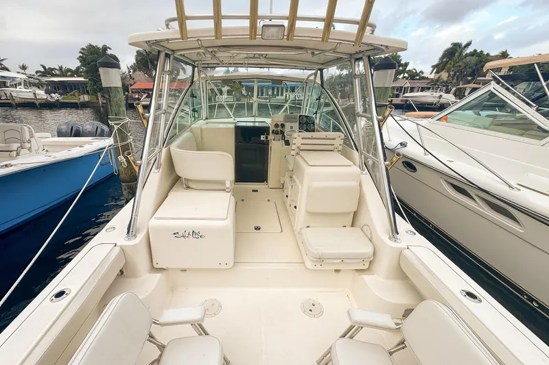 Slide: The Image of 2002 Pursuit 3000 Express boat interior with seating and control panel, docked at marina. - 17