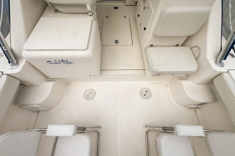 Slide: The Image of 2002 Pursuit 3000 Express boat interior with white seating and storage compartments. - 18