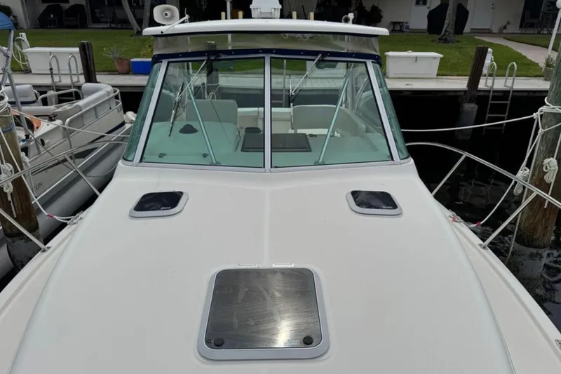 Slide: The Image of 2002 Pursuit 3000 Express boat docked, aerial view, featuring spacious deck and seating. - 2