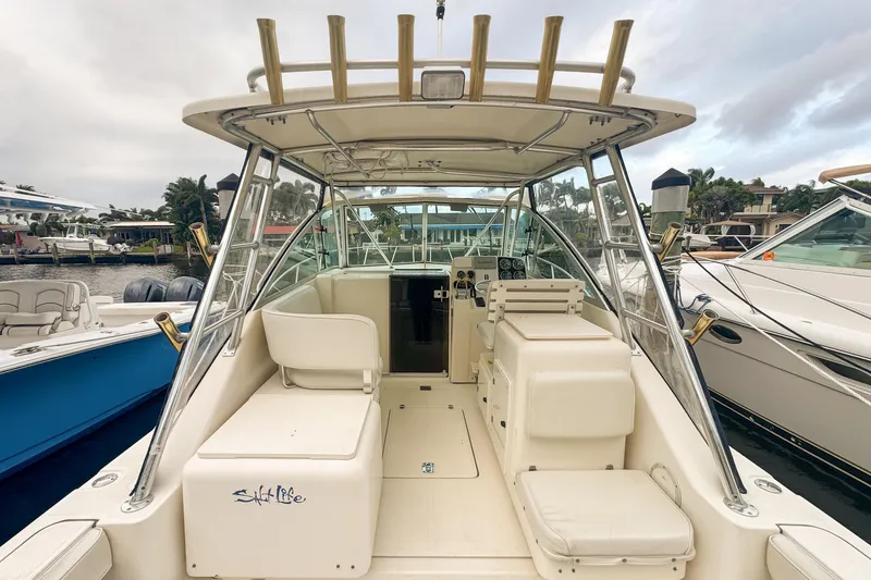 Slide: The Image of 2002 Pursuit 3000 Express boat interior with seating and helm, docked at marina. - 20