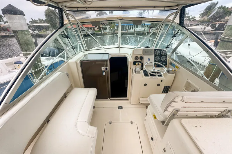 Slide: The Image of 2002 Pursuit 3000 Express boat interior with helm, seating, and marina view. - 24