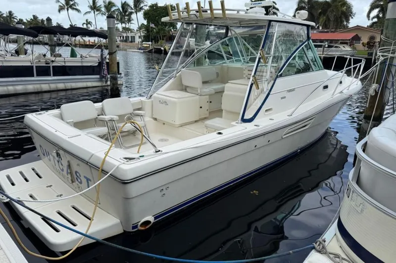 Slide: The Image of 2002 Pursuit 3000 Express boat docked at marina, front view. - 3