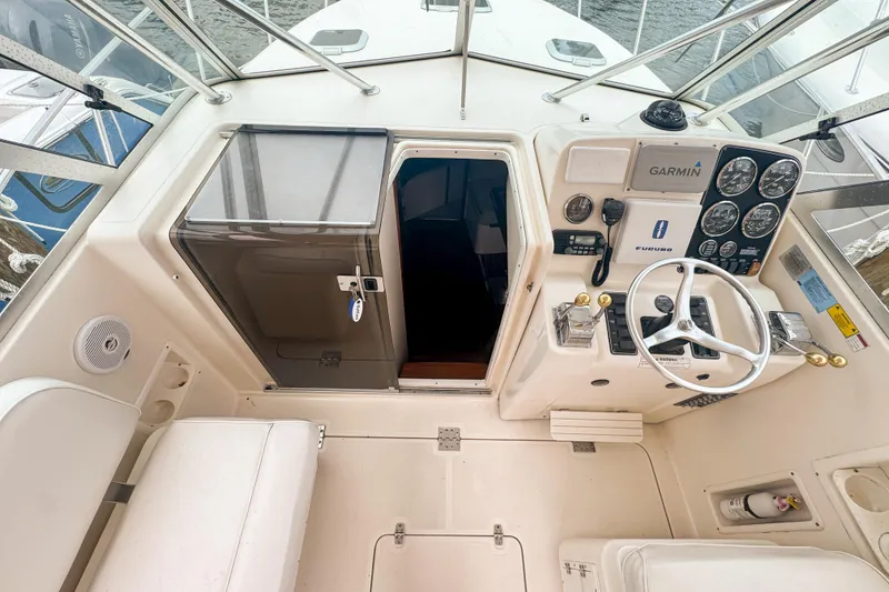 Slide: The Image of 2002 Pursuit 3000 Express boat cockpit with steering wheel and navigation instruments. - 30