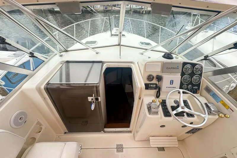 Slide: The Image of 2002 Pursuit 3000 Express boat cockpit with steering wheel and navigation instruments. - 31