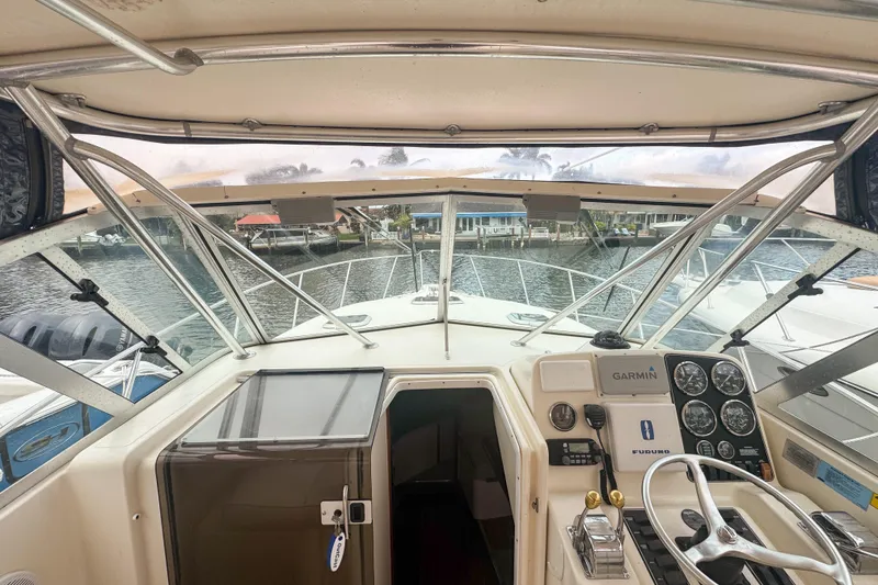 Slide: The Image of 2002 Pursuit 3000 Express boat cockpit with steering wheel and navigation equipment. - 32