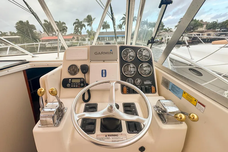 Slide: The Image of 2002 Pursuit 3000 Express boat helm with Garmin navigation and control gauges. - 35