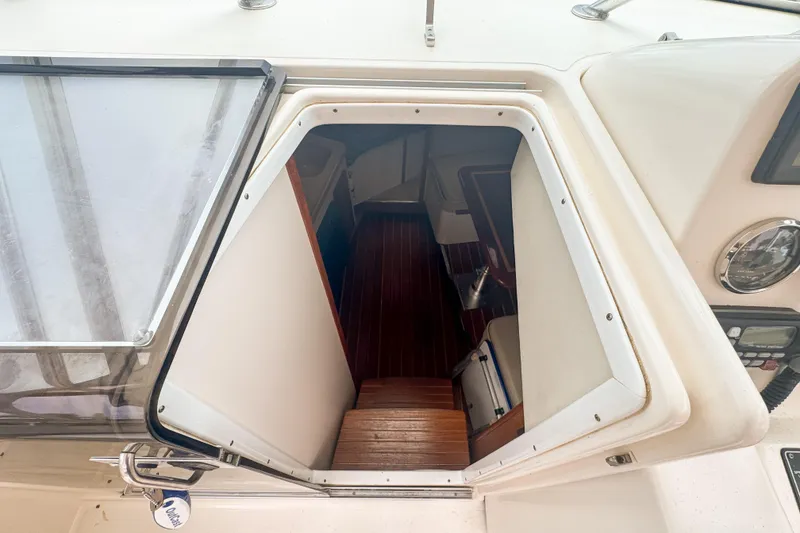 Slide: The Image of 2002 Pursuit 3000 Express cabin entrance with wooden steps and interior view. - 38