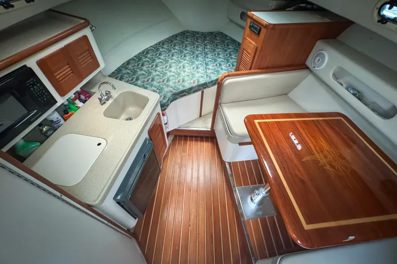 Slide: The Image of 2002 Pursuit 3000 Express cabin with kitchenette, seating, and bed. - 39