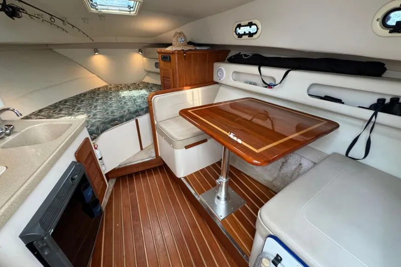 Slide: The Image of 2002 Pursuit 3000 Express cabin interior with wood table and seating area. - 40
