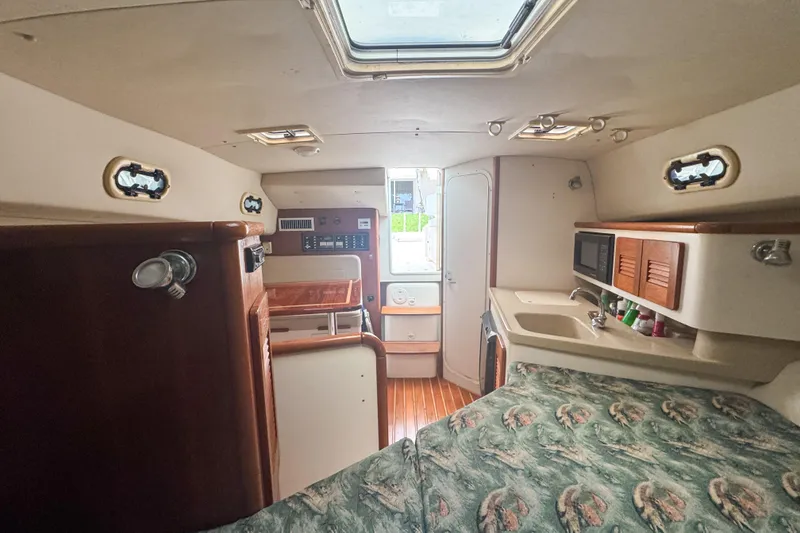 Slide: The Image of Interior of 2002 Pursuit 3000 Express boat with kitchenette and seating area. - 48