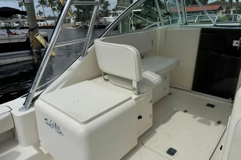 Slide: The Image of 2002 Pursuit 3000 Express boat docked at marina, surrounded by water and other boats. - 5