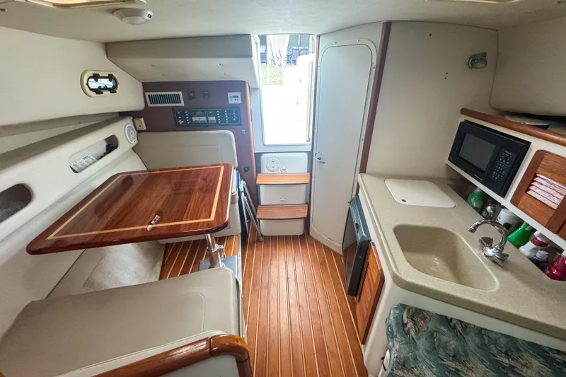 Slide: The Image of Interior of a 2002 Pursuit 3000 Express boat with kitchenette and seating area. - 52