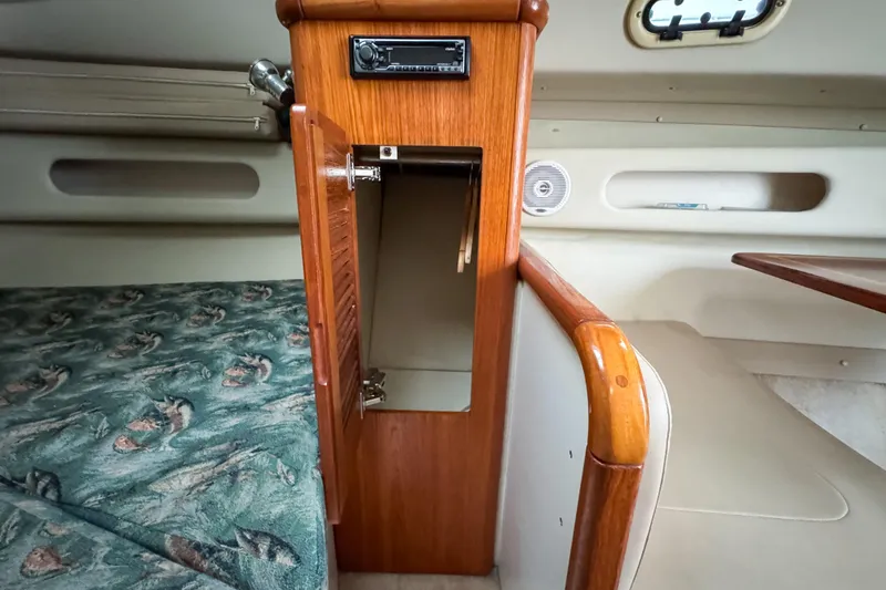 Slide: The Image of Interior of 2002 Pursuit 3000 Express boat with wooden cabinet and patterned bedding. - 55
