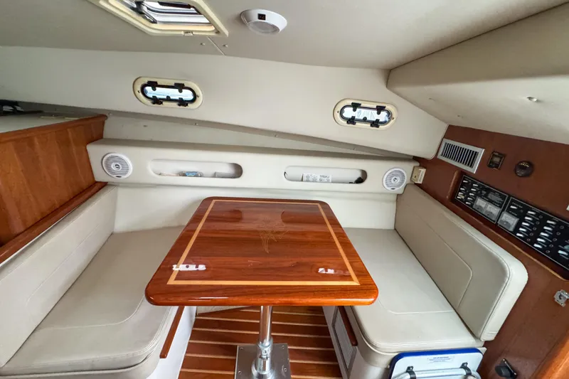 Slide: The Image of 2002 Pursuit 3000 Express cabin interior with wooden table and seating. - 61