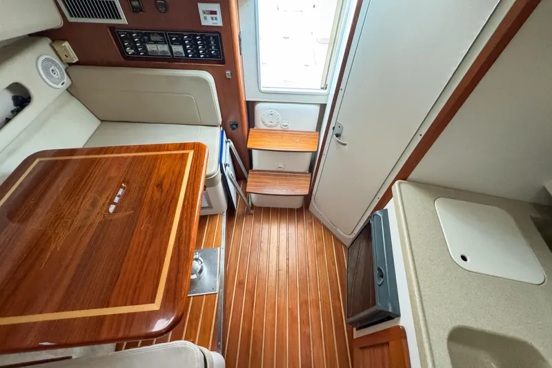 Slide: The Image of 2002 Pursuit 3000 Express cabin interior with wood flooring and compact kitchenette. - 63