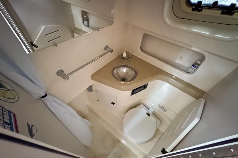 Slide: The Image of 2002 Pursuit 3000 Express boat bathroom with sink, toilet, and storage. - 68