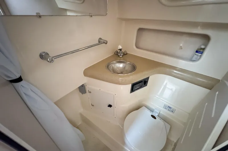 Slide: The Image of 2002 Pursuit 3000 Express boat bathroom with sink, toilet, and storage. - 69