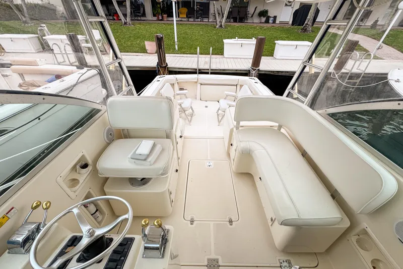 Slide: The Image of 2002 Pursuit 3000 Express boat interior with white seating and steering wheel. - 72