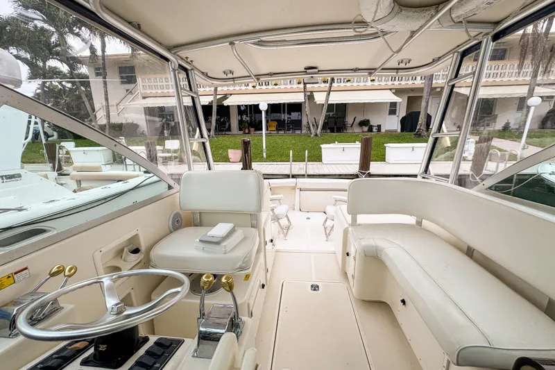 Slide: The Image of Interior view of 2002 Pursuit 3000 Express boat with helm and seating area. - 74