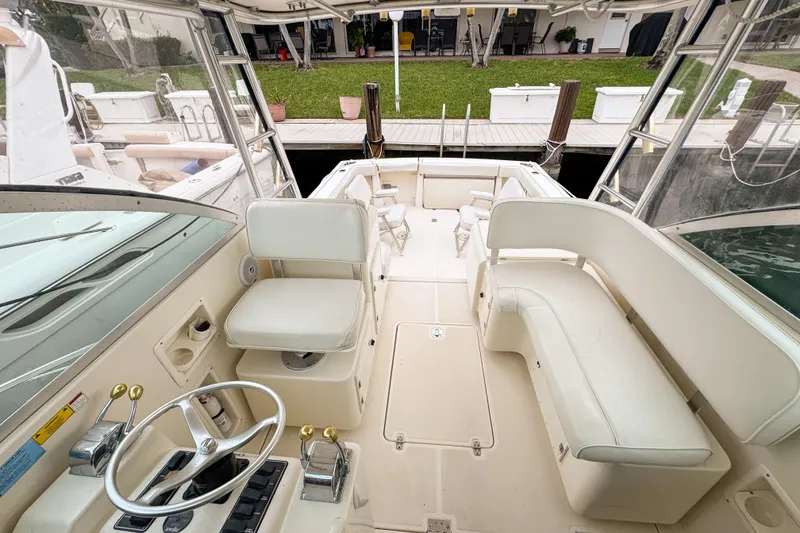 Slide: The Image of 2002 Pursuit 3000 Express boat interior with helm, seating, and dock view. - 75