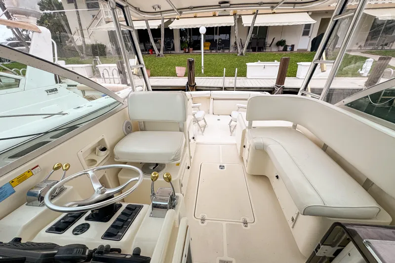 Slide: The Image of 2002 Pursuit 3000 Express boat interior with helm, seating, and controls. - 76