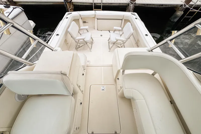 Slide: The Image of 2002 Pursuit 3000 Express boat interior with white seating and spacious deck. - 79